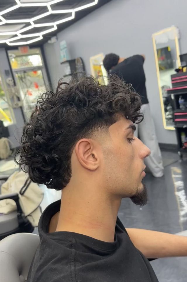 Curly hair with a sculpted taper and clean lineup